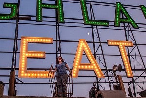 Photo of Nicole Possert in front of neon sign