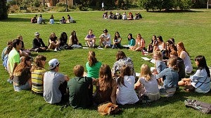 students sit in circles on lawn