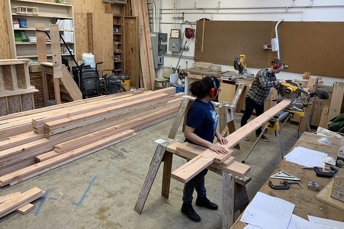 Photo of students working on house construction inside