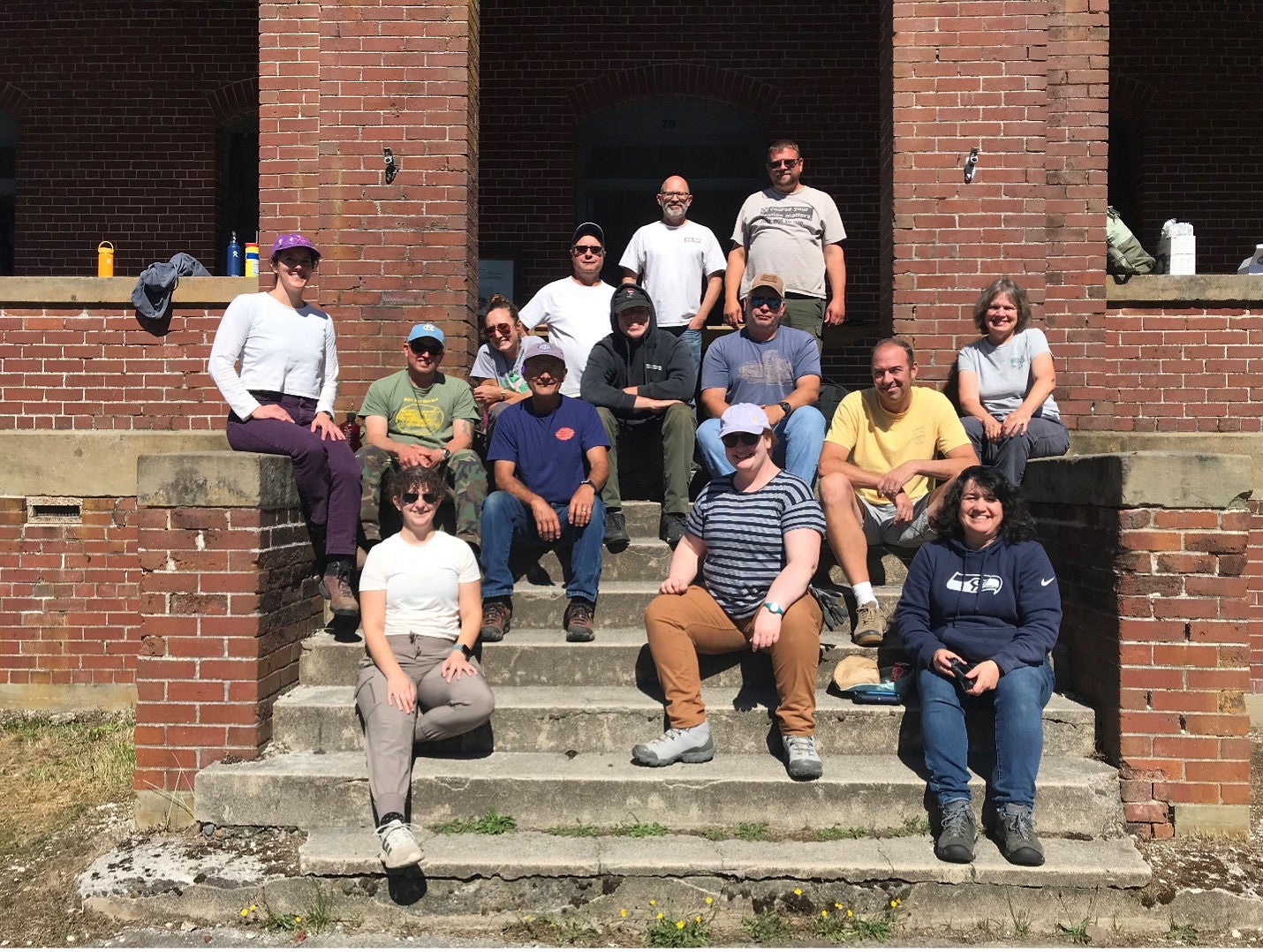 Group photo of the PNWPFS team in front of a historic brick structure at the 2023 PNWPFS site. 