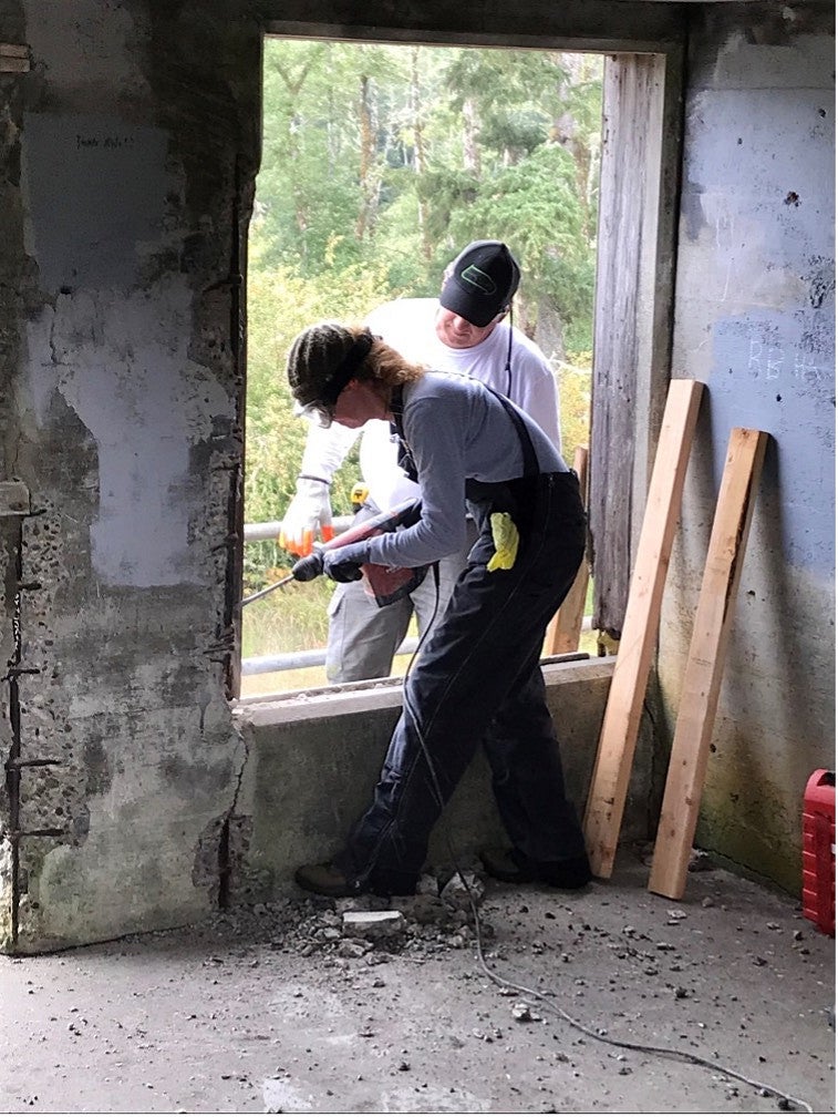 Work photo of two member of the 2023 PNWPFS team working in a window frame in a historic structure. 