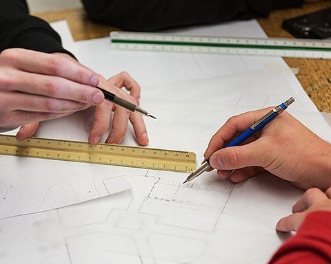 hands drawing with pencils and rulers