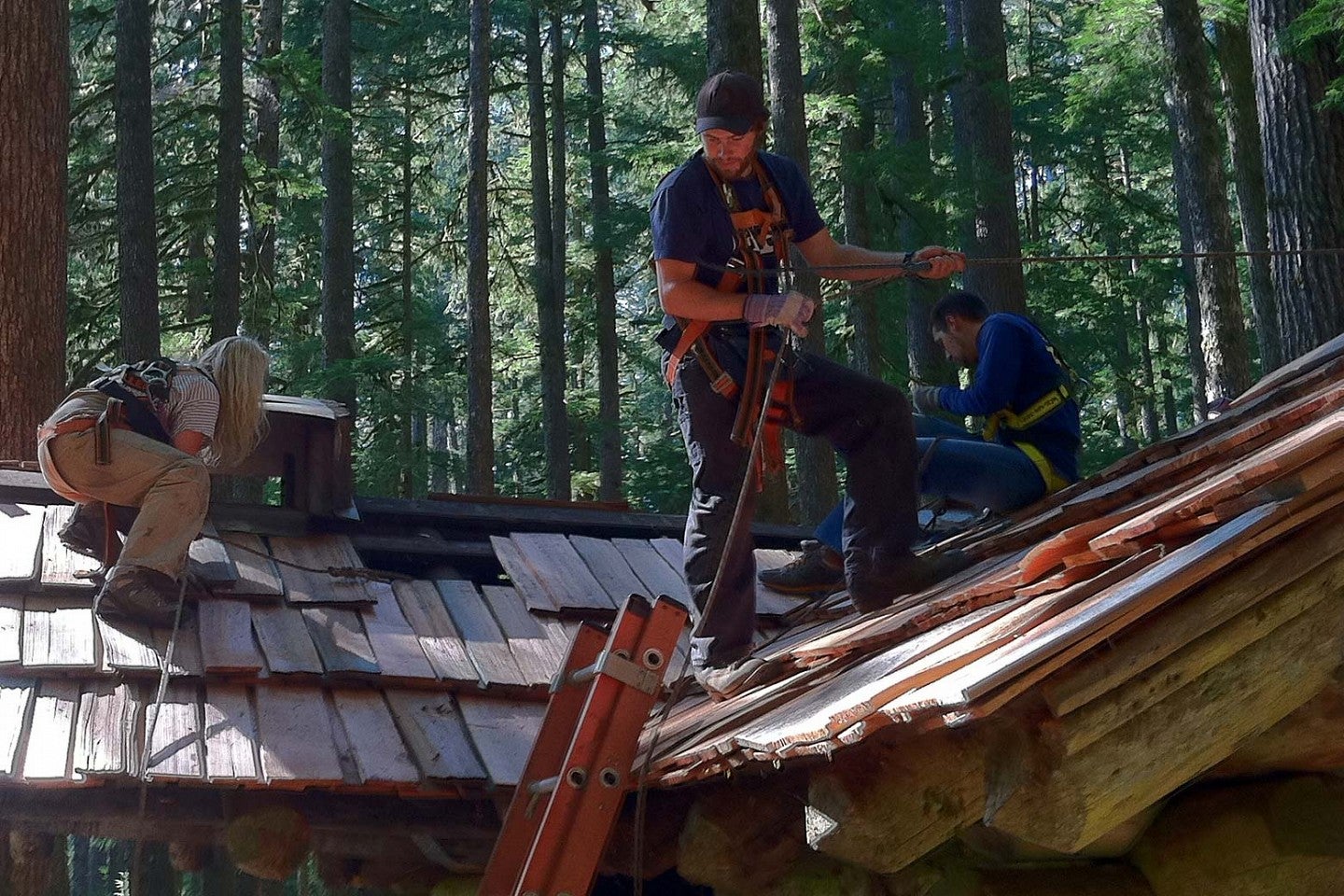 students work on roof of log building at the Pacific Northwest Field School