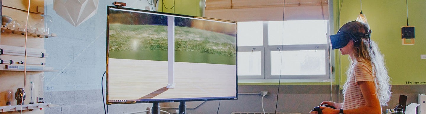 UO Student in Baker Lighting Lab Student in VR goggles at a TV screen