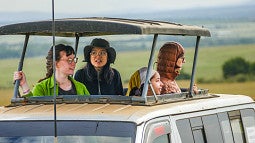 Photo of students on safari looking out from their van. 