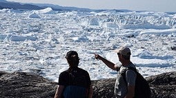 photo of two people looking at glaciers