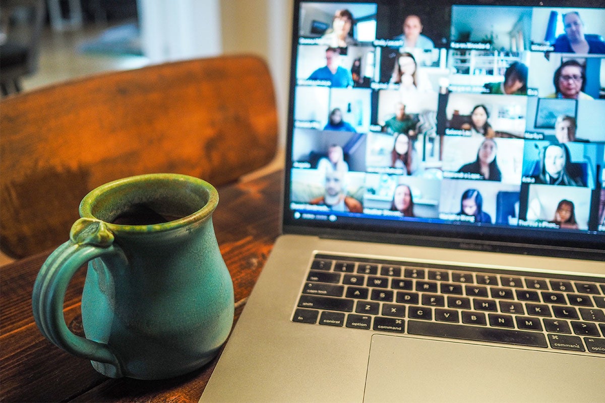 Photo of a mug and laptop with a video chat