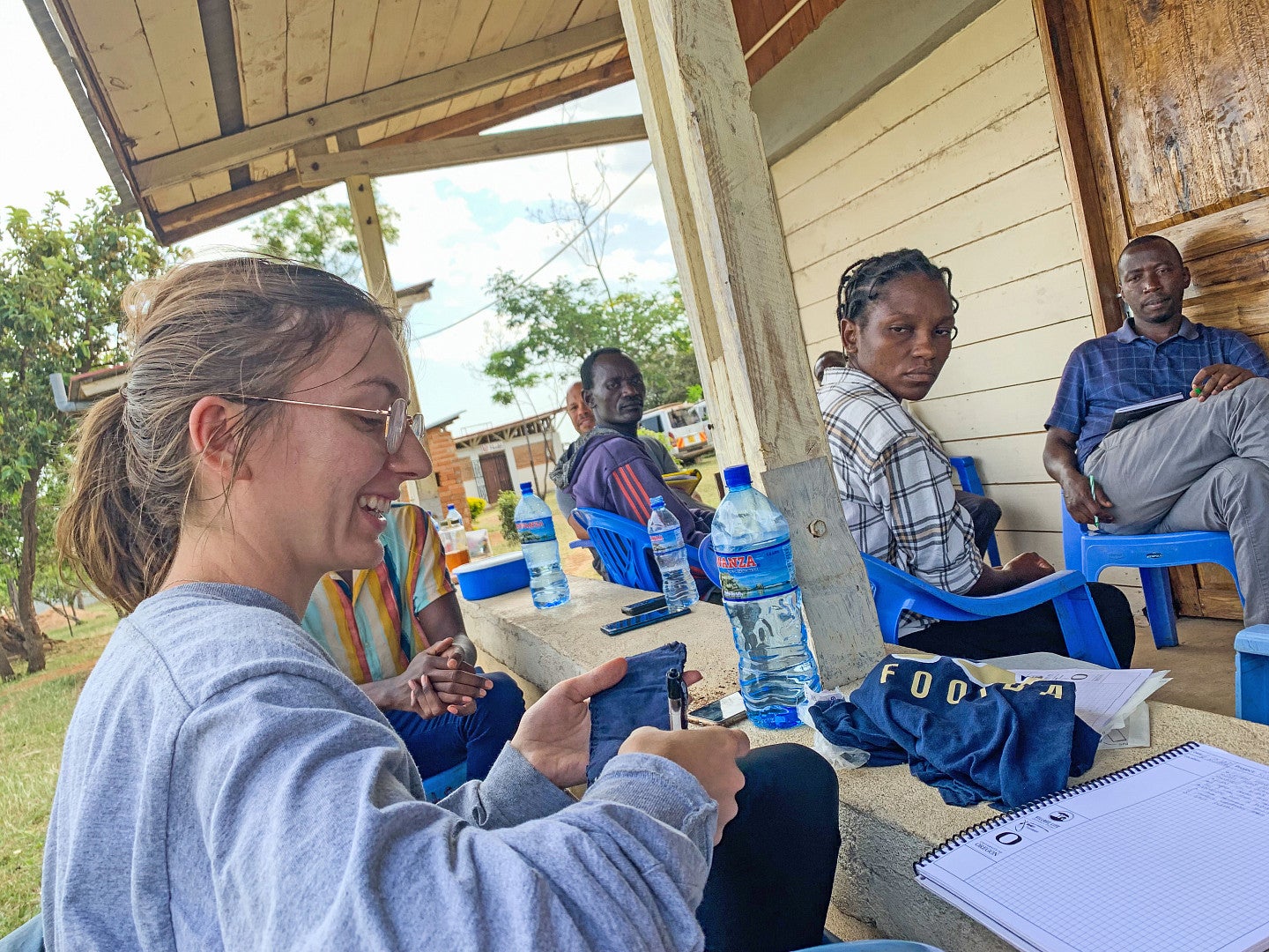 Photo of a UO student meeting with villagers to discuss menstruation product station project