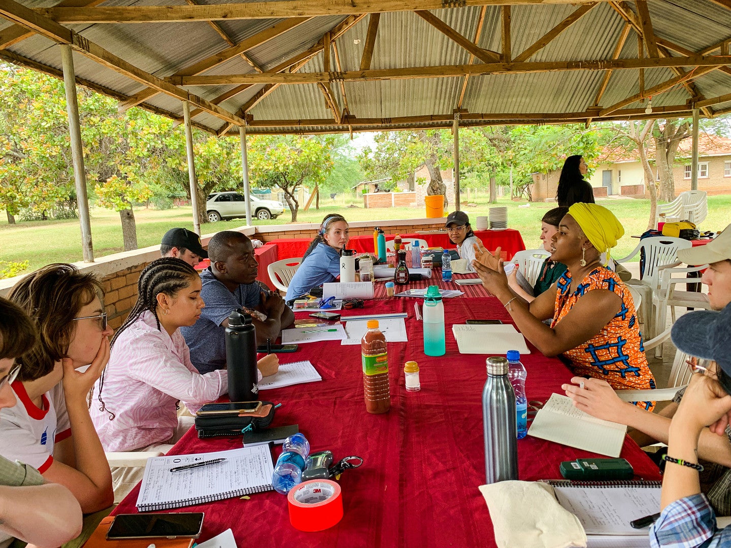 Photo of a meeting between students and a villager to discuss the needs of the village.