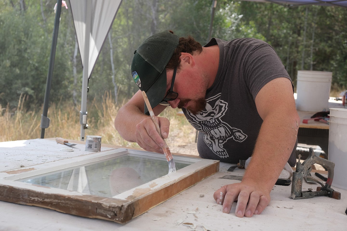 Photo from 2022 PNWPFS student working on a window frame on a table. 