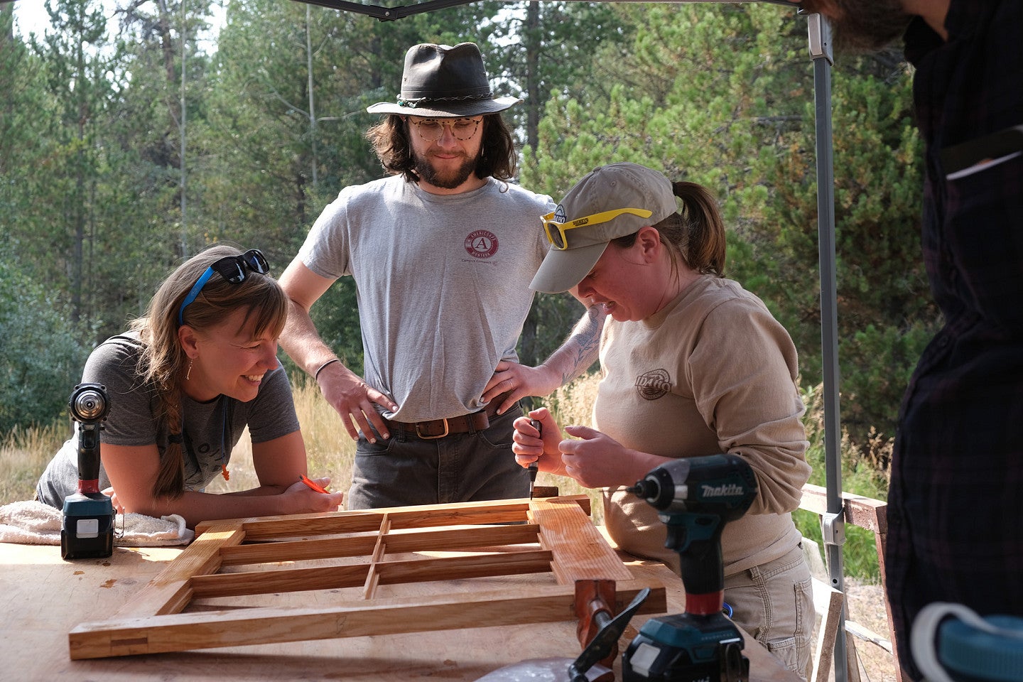 Photo from 2022 PNWPFS group working on a window frame on a table. 