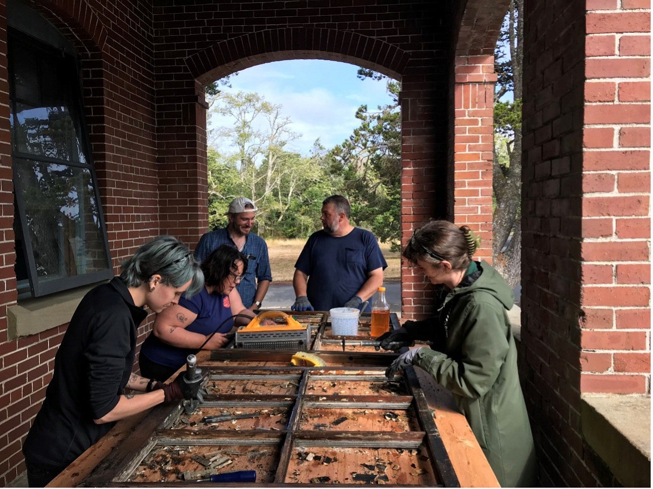 Group photo of the PNWPFS team looking over a window pane. 