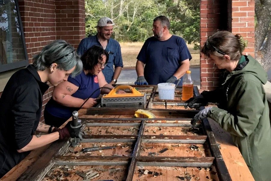 Group photograph of HP students working on a window. 