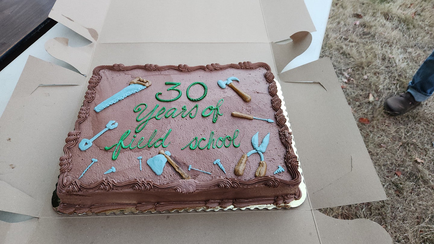 Chocolate cake decorated with frosting tools. It reads, 30 years of field school.
