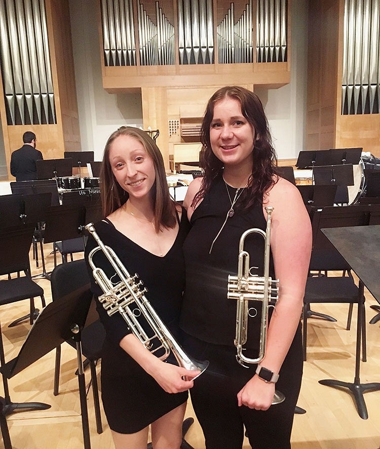 two people holding trumpets