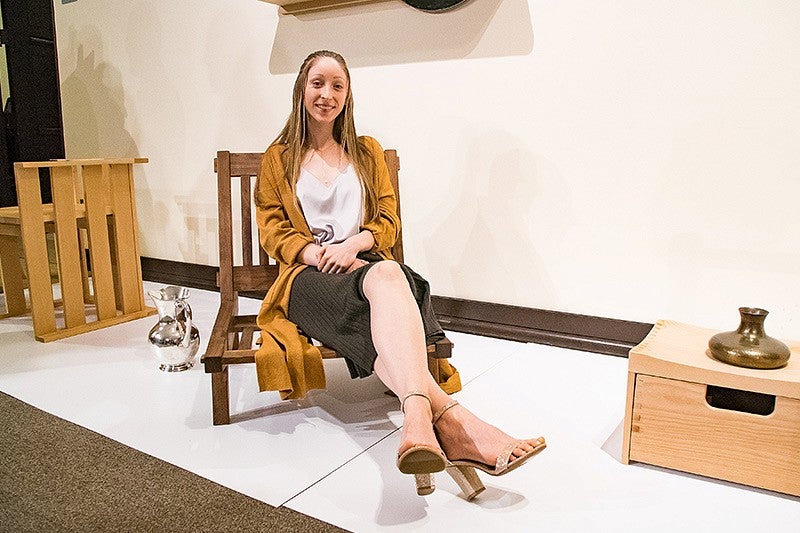 Student Stella Mae Christ sitting in a wooden chair