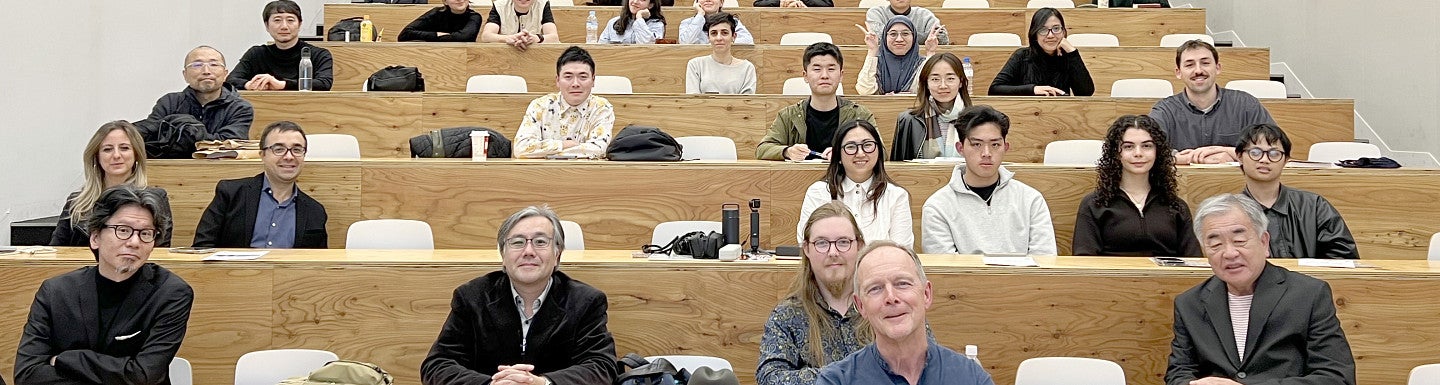 Photograph of Kevin Nute in front of a crowd in Japan. 