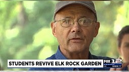 Image shows man in glasses and a hat looking into the camera talking about working with historic windows at the Elk Rock Gardens in Portland. 