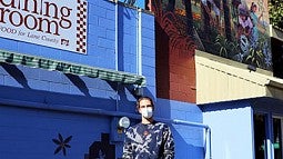 Photo of a man in front of a building